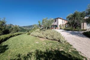 a house with a gravel road in front of a yard at Terre di Cocomo in Borgo a Buggiano