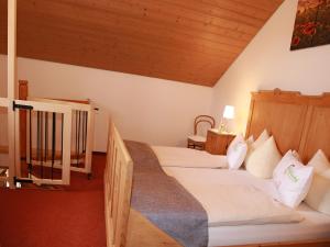 a bedroom with two beds and a wooden ceiling at Andreashof in Heimenkirch