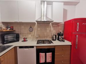 uma cozinha com um fogão e um frigorífico vermelho em Il Ciliegio - House with Garden & Wonderful View em Pietra la Croce