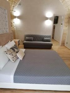 a large bed in a room with a couch at LA DIMORA DEL PRINCIPE-Loft in Trani