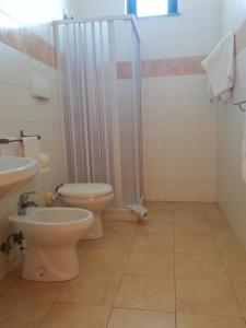 een badkamer met een toilet, een douche en een wastafel bij Villaggio Artemide in Giardini Naxos