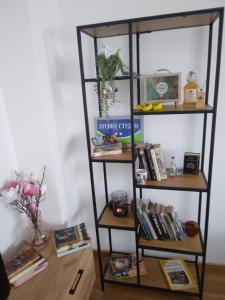 un estante de libros con libros y otros artículos. en Studio apartman Promenada, en Sarajevo