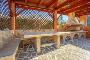 a patio with a stone bench and an outdoor oven at Villa Totta in Alikanas