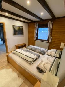 a bedroom with two beds and a window at Feriendorf am Hohen Bogen Arrach Haus 69 in Arrach