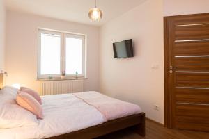 sypialnia z łóżkiem i telewizorem na ścianie w obiekcie DreamHouse Apartament Baltic Amber Jagiellońska Darłówko Wschodnie w Darłówku