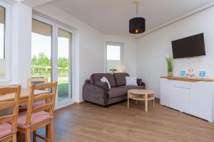 salon z kanapą i stołem w obiekcie DreamHouse Apartament Baltic Amber Jagiellońska Darłówko Wschodnie w Darłówku