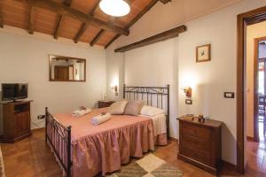 a bedroom with a bed with pink sheets and a television at L'Oasi della Pergola in Castiglione del Lago