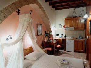 a bedroom with a white bed and a kitchen at Palazzo di Pietro in Chania