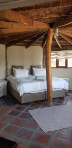a bedroom with two beds in a room with wooden ceilings at Avani Lodge Private Nature Reserve in Botrivier +85 photos