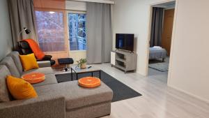 ein Wohnzimmer mit einem Sofa und einem TV in der Unterkunft Hamina Orange Apartments Ilves in Hamina