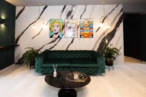 - un canapé vert dans une pièce ornée de peintures murales dans l'établissement THE Penthouse at Eco Smart Apartments, à Nuremberg