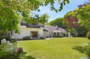 a house with a large lawn in front of it at Craiglea Newlands - Villa with Pool & Tennis Court in Cape Town