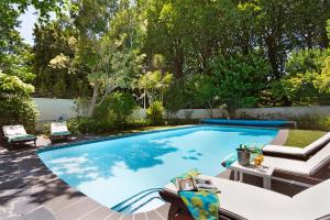 a swimming pool in a backyard with a patio furniture at Craiglea Newlands - Villa with Pool & Tennis Court in Cape Town