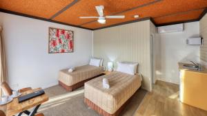 een kamer met 2 bedden en een plafondventilator bij Motel Meneres in Corowa