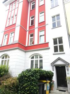 czerwono-biały budynek z czarnymi drzwiami w obiekcie Get-your-flat - Tiny Flat in Gründerzeithaus, super sweet, Kreuzviertel - 50 m2 EG Haustier auf Anfrage w Dortmundzie