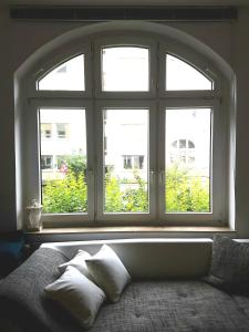 duże okno w pokoju z łóżkiem i poduszkami w obiekcie Get-your-flat - Tiny Flat in Gründerzeithaus, super sweet, Kreuzviertel - 50 m2 EG Haustier auf Anfrage w Dortmundzie