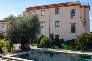 ein Gebäude und ein Pool vor einem Gebäude in der Unterkunft SorrentoBay in Sant'Agnello