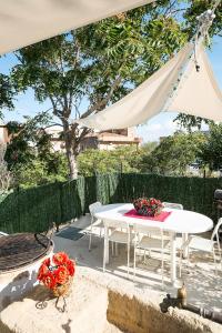 une table et des chaises blanches sous une tente blanche dans l'établissement Casa Mary, à Castellammare del Golfo