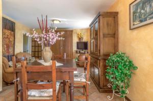 a dining room with a table and a vase of flowers at Casale Belvedere "L'Ulivo" e "La Terrazza" in Massarosa