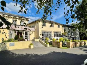 a large yellow house with a staircase in front of it at Reigate Manor Hotel in Reigate