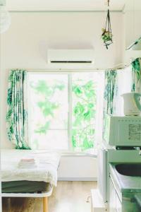 a room with a window and a table with a microwave at *Beautiful, Sunny, & Quiet Apt Close to Metro in Tokyo