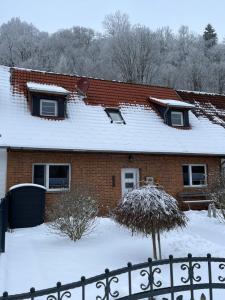 ein Haus mit einem schneebedeckten Dach in der Unterkunft Mompels in Höhlenort Rübeland