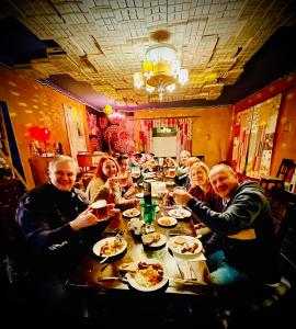 un grupo de personas sentadas alrededor de una mesa comiendo comida en HARABURDI® Recyclart Hotel en Kostelec nad Orlicí