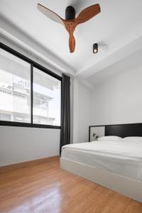 CASA BLANCA Dusit في Dusit: غرفة نوم بسرير ومروحة سقف