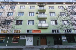 a green building with a sign on the front of it at FLEXIHOME SK - Zborovska - garage Parking with electricity - 2 bedrooms in Košice