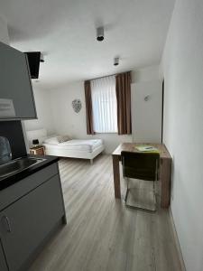 eine Küche und ein Wohnzimmer mit einem Tisch und einem Sofa in der Unterkunft Aparthotel Gartenstadt in Bamberg