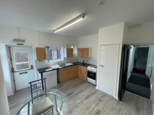 an empty kitchen with a table and a chair in it at ISUITES in Newcastle under Lyme +30 photos