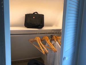 una bolsa sentada en un estante en un armario con perchas en Haus Löwe - Komplettes Ferienhaus am Badesee en Erzgrube