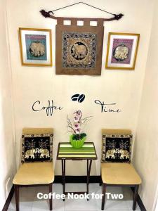 two chairs and a table and some pictures on the wall at Condominium Suites at Chateau Elysee - Ritz in Manila