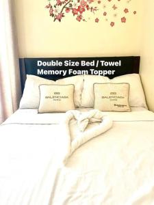 Una cama con dos almohadas y un cartel en la pared. en Borbon's Condo Suite, en Manila 12 fotos más