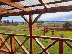 a view of a field from a wooden building at Domki Na Wzgórzu - domek nr 2 in Mrągowo