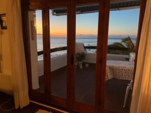 a view of the ocean from a room with sliding glass doors at Sea breeze in Vilanova i la Geltrú