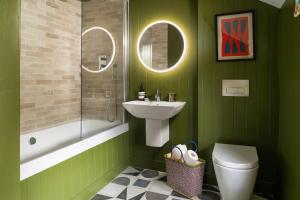 a green bathroom with a sink and a toilet at Finest Retreats - Bryn Mair in Dolwyddelan +32 photos