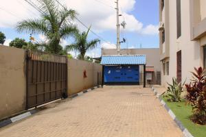 a driveway with a blue door and a fence at Matola View Residence in Matola