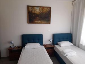 a room with two beds and a picture on the wall at Emmanouela Studios in Sitia