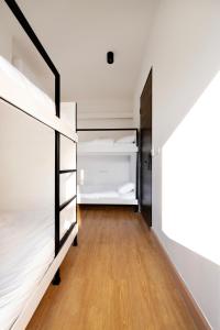 um quarto com beliches brancos e piso em madeira em CASA BLANCA Dusit em Dusit