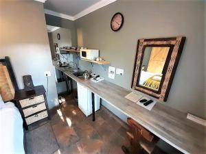 a room with a counter with a mirror on the wall at Edenville Guesthouse in Lichtenburg