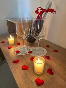 two wine glasses and candles on a table with hearts at Mura Guest Room in Terralba