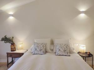 Una cama blanca con dos almohadas encima. en Areitio etxea - casa con jardin, en Mallavia