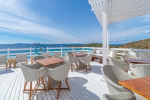 a deck with tables and chairs and a view of the ocean at Hotel Perrakis in Kipri