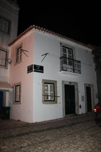 里斯本的住宿－Lisbon Castle Apartment，粉红色和白色的建筑,设有窗户和阳台