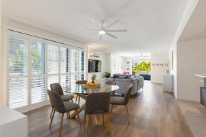 uma sala de jantar e sala de estar com mesa e cadeiras em City oasis - 3 BR apt. on Maroochy river, pool, AC em Maroochydore