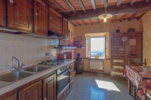 a kitchen with wooden cabinets and a sink and a window at Casale Belvedere "L'Ulivo" e "La Terrazza" in Massarosa