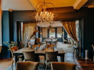 a dining room with a table and chairs and a chandelier at Verzon House in Ledbury