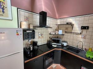 a kitchen with a sink and a refrigerator at Villa la Playa pieds dans l'eau lagon + piscine in Saint-Gilles les Bains +14 photos