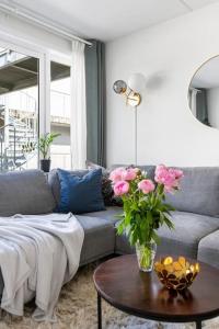 a living room with a couch and a table with flowers at Live on the roof of Oslo city center in Oslo